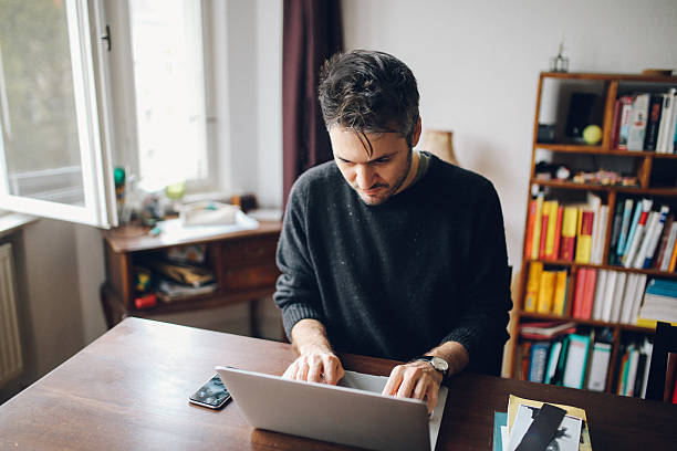 istock Young man doing a freelance job from home 638697170