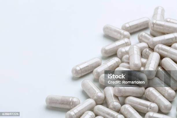 Heap Of White Capsules Medications On White Background Stock Photo - Download Image Now