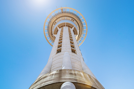 Sky Tower in Auckland from below against the sun und deep blue sky. Auckland, New Zealand, Oceania.
