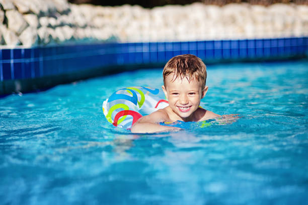 istock young happy child boy swimming in pool with ring.   into 638701690