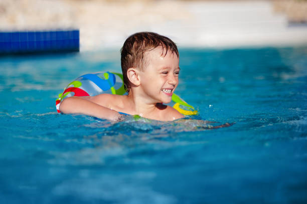 istock Happy little boy with variegated life ring has fun in 638702040