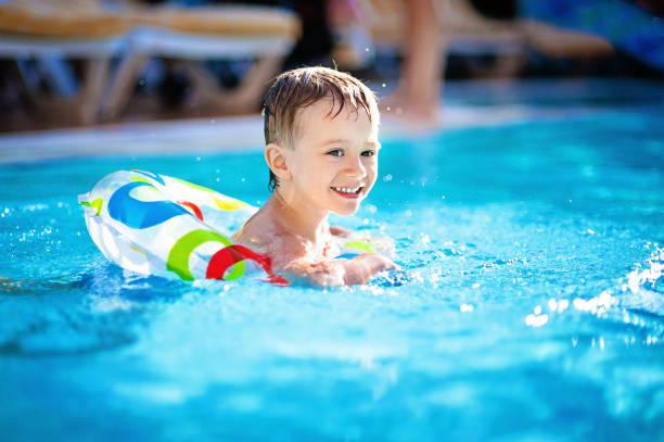 istock Cute little boy swimming in the pool in rubber ring 638702678