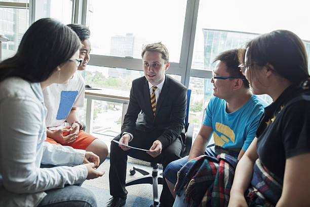bildungsberater mit chinesischen studenten im büro - english culture talking men listening stock-fotos und bilder