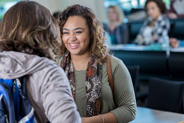 istock Cheerful mixed race college student talks with male friend 638711684