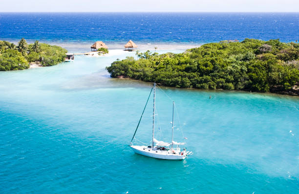 Heaven in Roatan A bird's eye view of a sailboat in the blue ocean of Roatan, Honduras honduras stock pictures, royalty-free photos & images