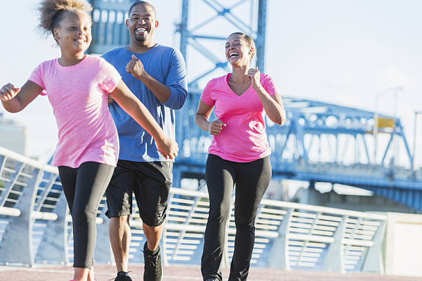 black family staying fit, power walking on waterfront - walking exercising relaxation exercise group of people imagens e fotografias de stock