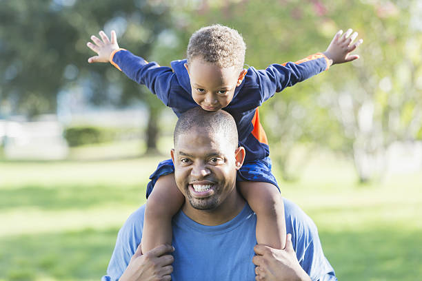 istock Little boy sitting on father's shoulders 638712636