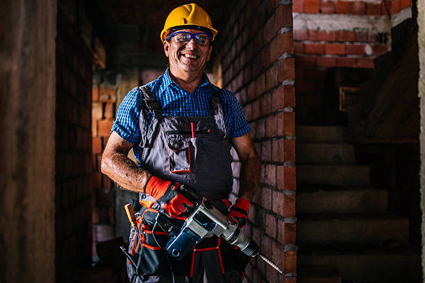 I am ready for drilling Making new holes. Senior construction worker working on a construction site, using a drill to drill a hole. helmet hardhat protective glove safety stock pictures, royalty-free photos & images