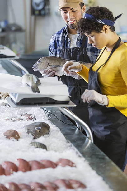 istock Young mixed race couple working in fish market 638713168