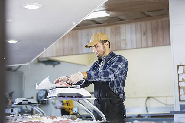 istock Hispanic man working in seafood market, weighing fish 638713178