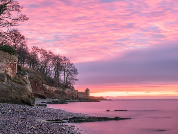 Colorful sunrise over rocky beach near Kirkcaldy, Scotland stock photo
