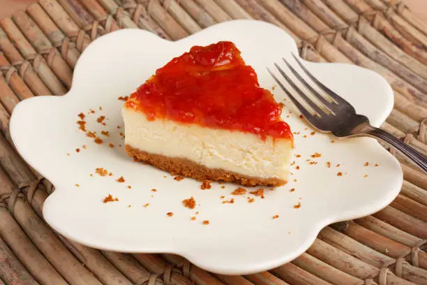 Cheesecake with brazilian goiabada jam of guava on plate on wooden table. Selective focus
