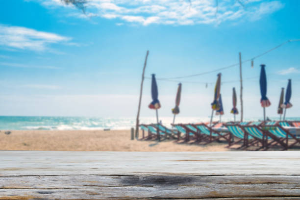 istock Wood table top on blurred blue sea and white sand 638718880
