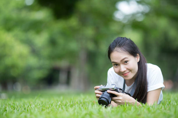 istock girl with camera lie down on grass 638719602