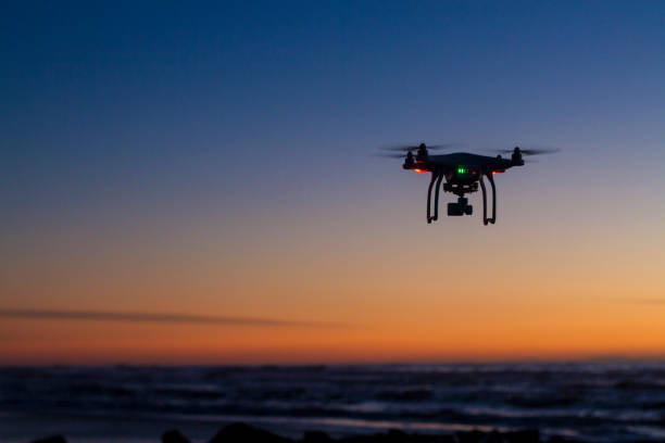 dron sobrevolando el océano al amanecer - robot fotos fotografías e imágenes de stock