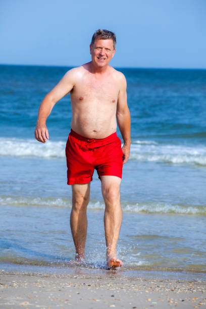 istock handsome man walking at the  beach 638730290