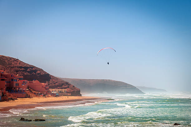 Parachutist on the coast of Sidi Ifni, Atlantic Ocean,Morocco Parachutist on the coast of Sidi Ifni Morocco, Legzira,  - March 25, 2014: Paraglider over Beach Legzira, Morocco,North Africa,Nikon D3x airfoil photos stock pictures, royalty-free photos & images