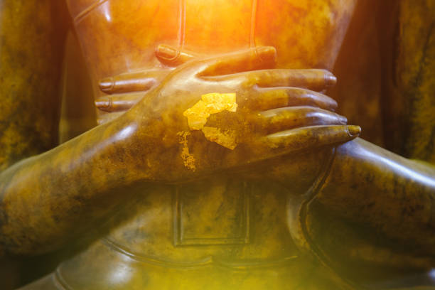 close up Hand on buddha  statue with lighting effect.  Selective focus Hand buddha statue.