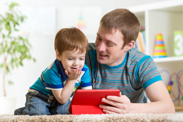 istock father and son kid play with tablet computer indoors 638745790