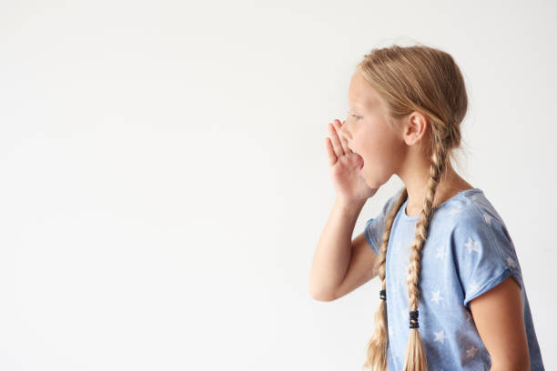 Little African-American Curly Haired Girl with Sinusitis Problems is Feeling Displeased and Blowing Nose in Napkin During a Walk in City Park During a Summer Day.