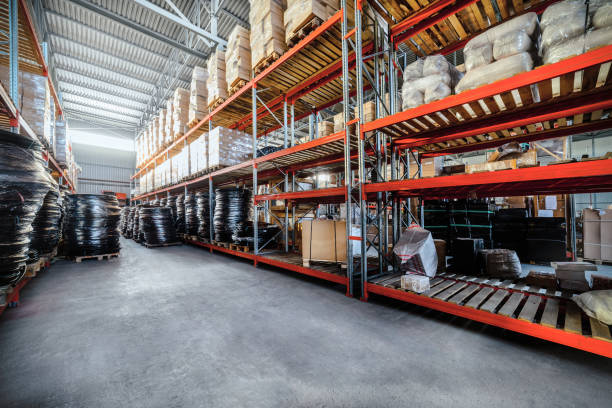 Long shelves with a variety of boxes and containers. Warehouse industrial goods. Large long racks. Cardboard boxes and coiled plastic tube. Toning the image. hardware store photos stock pictures, royalty-free photos & images