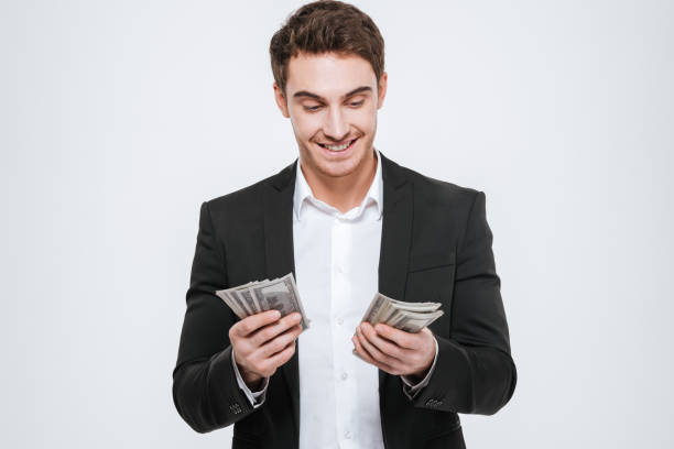 istock Happy businessman standing at studio holding money 638750304