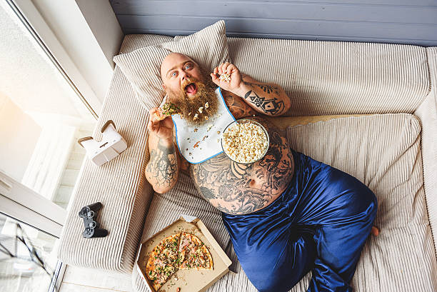 istock Fat guy eating junk food with enjoyment 638752036