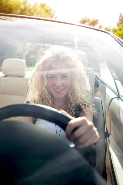 istock Smiling woman driving convertible car. 638753740