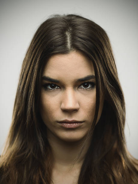 Close-up portrait of depressed young woman Close-up portrait of sad young woman. Depressed female against gray background. Vertical studio photography from a DSLR camera. Sharp focus on eyes. mediterranean woman portrait stock pictures, royalty-free photos & images