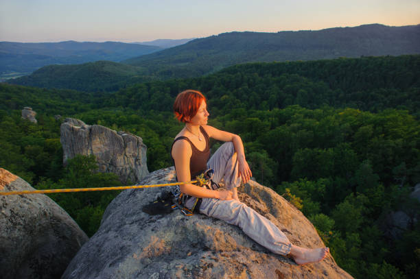 istock Girl climber on mountain peak on high altitude in evening 638757442