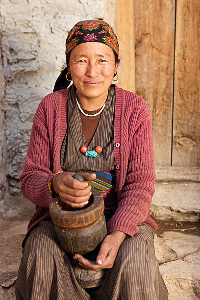 istock Tibetan woman using a mortar to make  flour. Mustang, Nepal 638758086