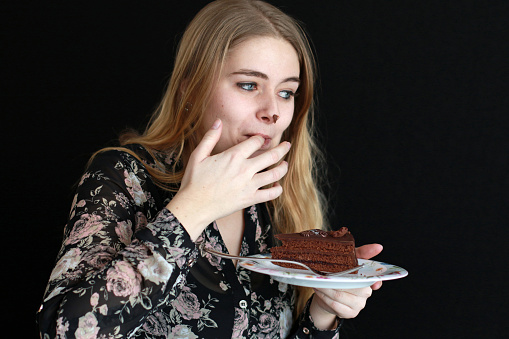 A woman enjoys some chocolate cake.