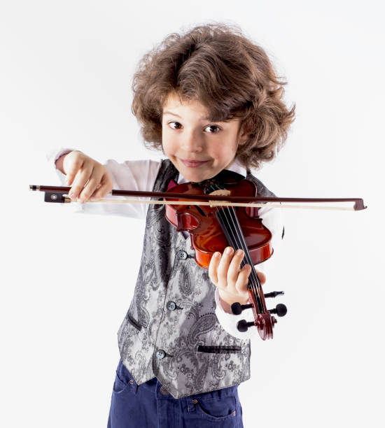 istock Cute curly-haired boy in waistcoat playing the violin leaning forward. 638759648