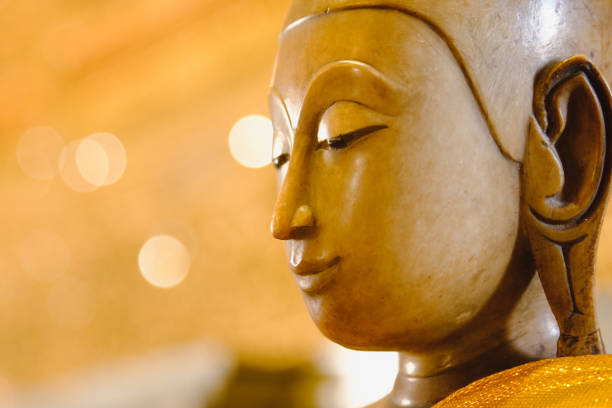 close up face on buddha head statue with Bokeh background and lighting effect.      Selective focus face buddha statue.