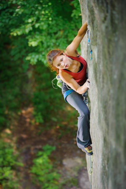 istock Beautiful woman climber climbing steep rock with rope 638759862