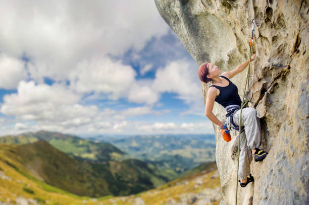 istock Female rock climber on steep overhanging rock cliff 638761978