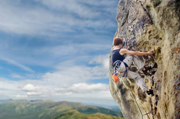 istock Female rock climber on steep overhanging rock cliff 638762484