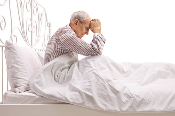 istock Depressed senior lying in bed with his head down 638765884