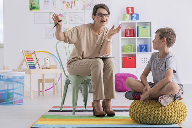 School counselor and pupil Positive school counselor and pupil sitting in light classroom student counseling stock pictures, royalty-free photos & images