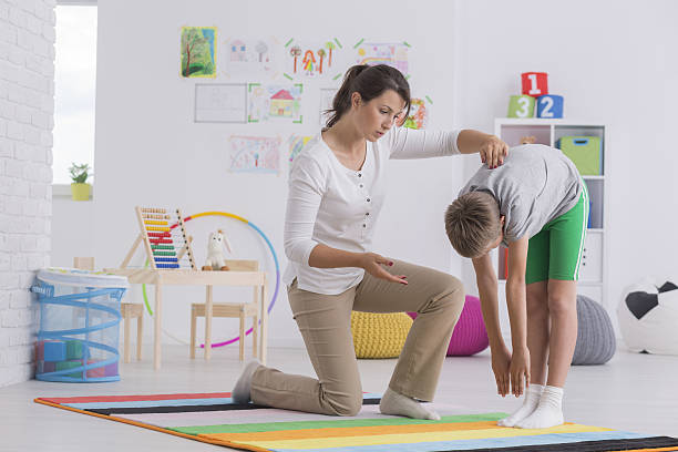 理学療法士と運動する子供 - scoliosis ストックフォトと画像