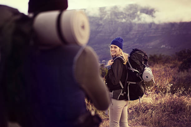 istock Smiling female hiker looking at man on field 638767324