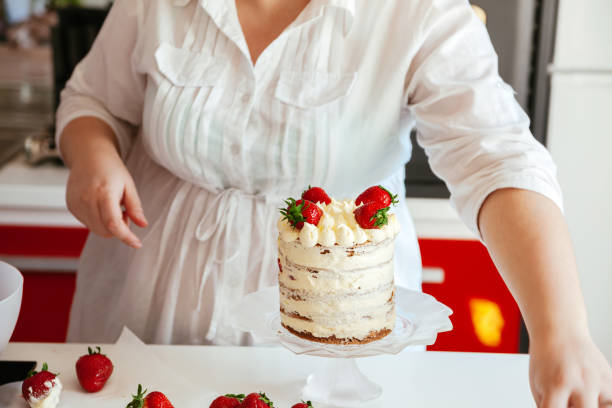 istock Woman Carefully Icing The Cake 638769150