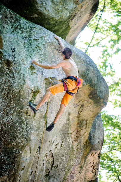 istock Male rock climber climbing with rope on a rocky wall 638769426