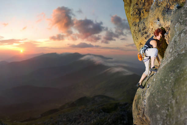 istock Female climber climbing with rope on a rocky wall 638770834