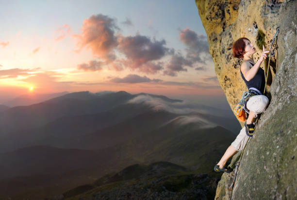 istock Female climber climbing with rope on a rocky wall 638770982