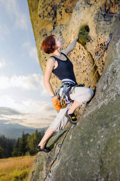 istock Female climber climbing with rope on a rocky wall 638771098