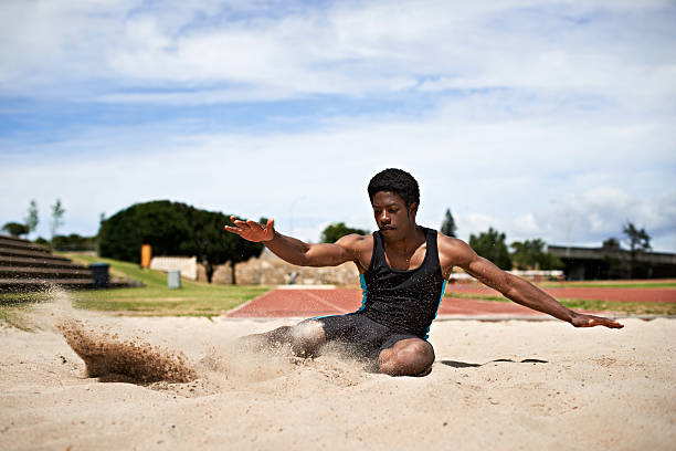 Nailed the landing! Shot of a young woman landing in sand after a long jump long jump stock pictures, royalty-free photos & images