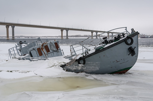 Shipwreck in a frozen river covered with ice