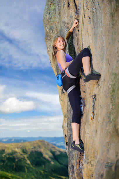 istock Female climber climbing with rope on a rocky wall 638773402