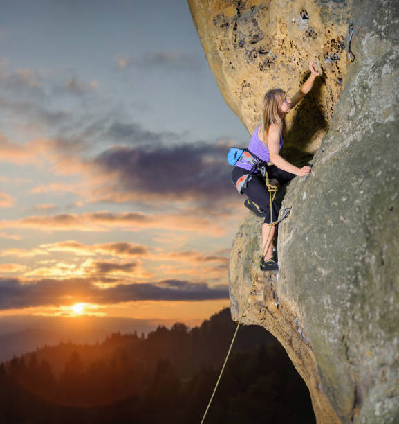 istock Female climber climbing with rope on a rocky wall 638774852